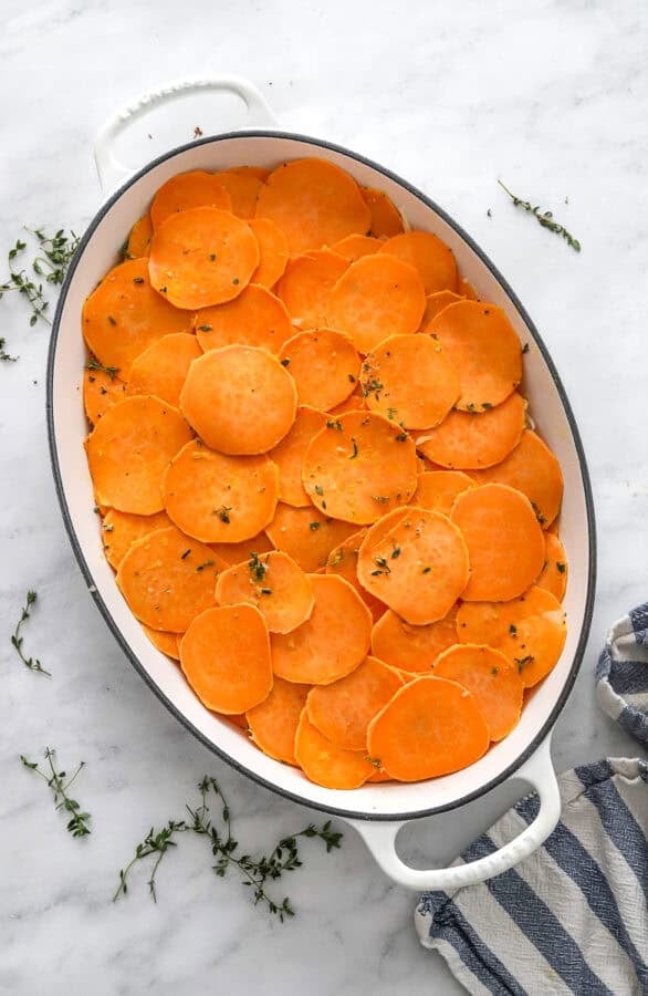 Layered sweet potato gratin with no cheese added in a white grain dish.