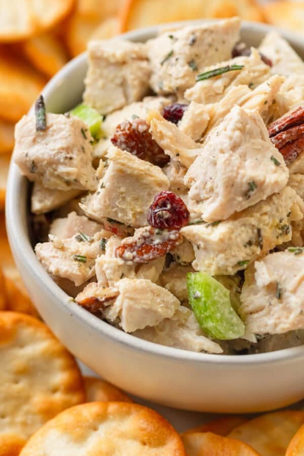 Bowl of creamy turkey salad with crackers around it.
