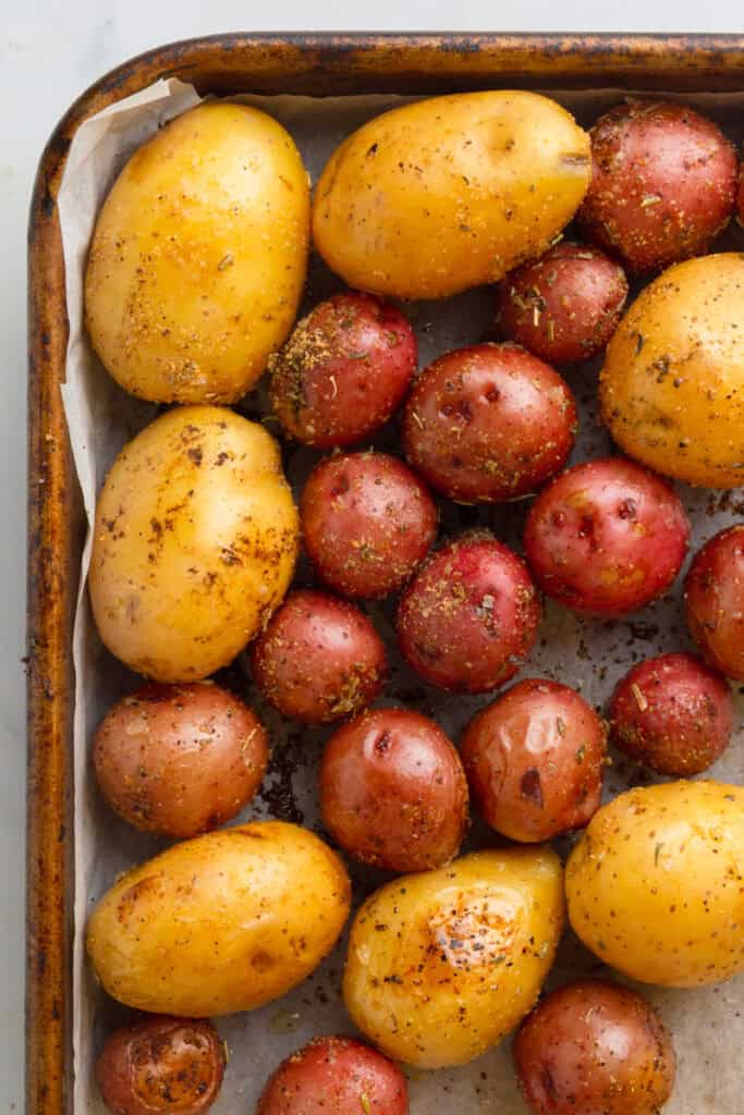 Baby white and red potatoes on a baking sheet. 
