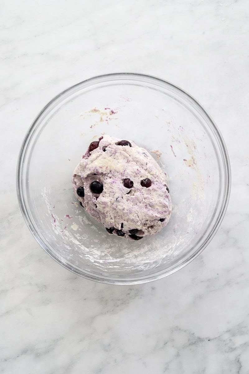 Blueberry bagel dough in a glass bowl.
