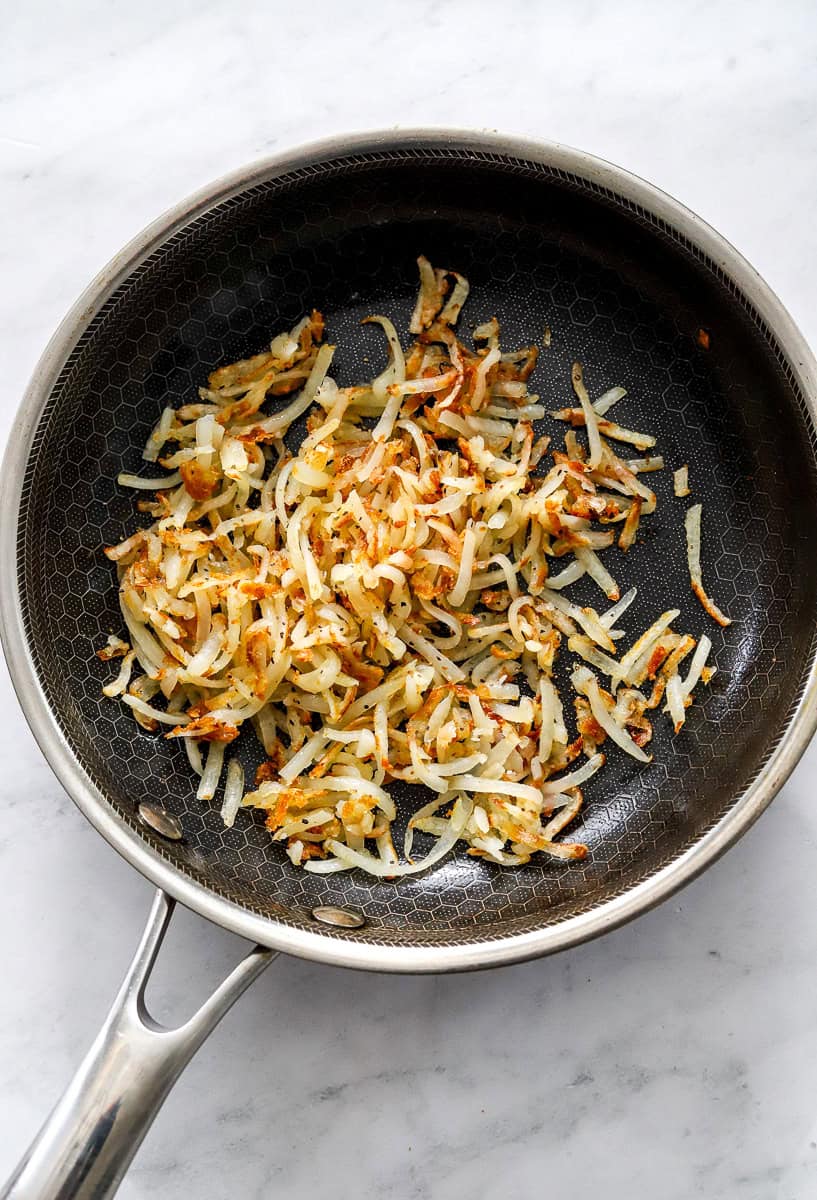 Cooke shredded potato in a saute pan.