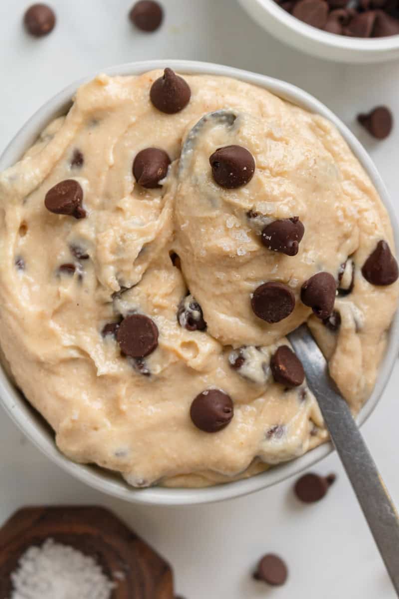 Cottage cheese cookie dough with chocolate chips in a bowl with more ingredients around it.