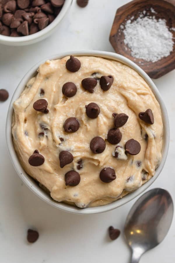 Cottage cheese cookie dough with chocolate chips in a bowl with more ingredients around it.