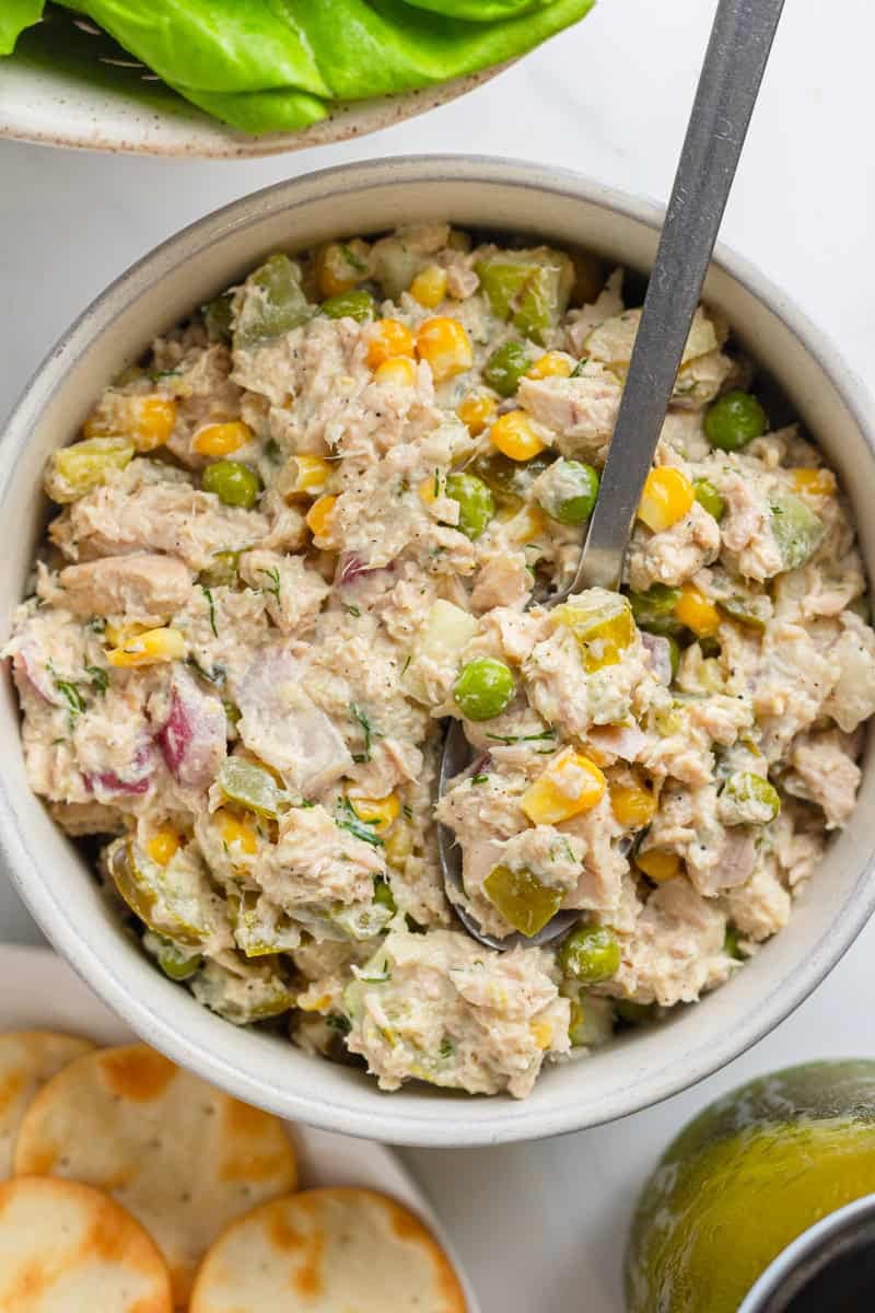 Bowl of Matthew mcpconaughey tuna salad mixed with a spoon in the bowl with it. 