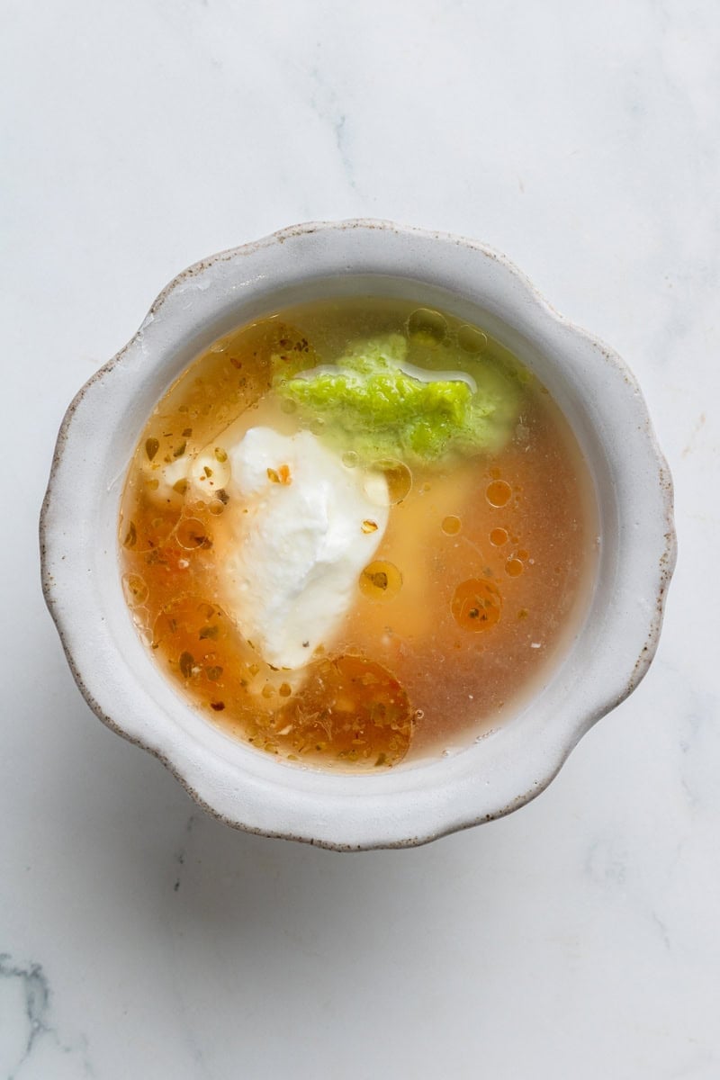 Dressing for tuna sald in a bowl before being blended.