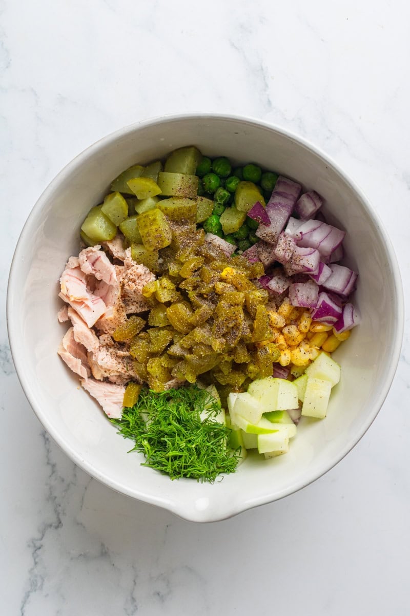 Tuna salad ingredients in a bowl before being mixed up. 