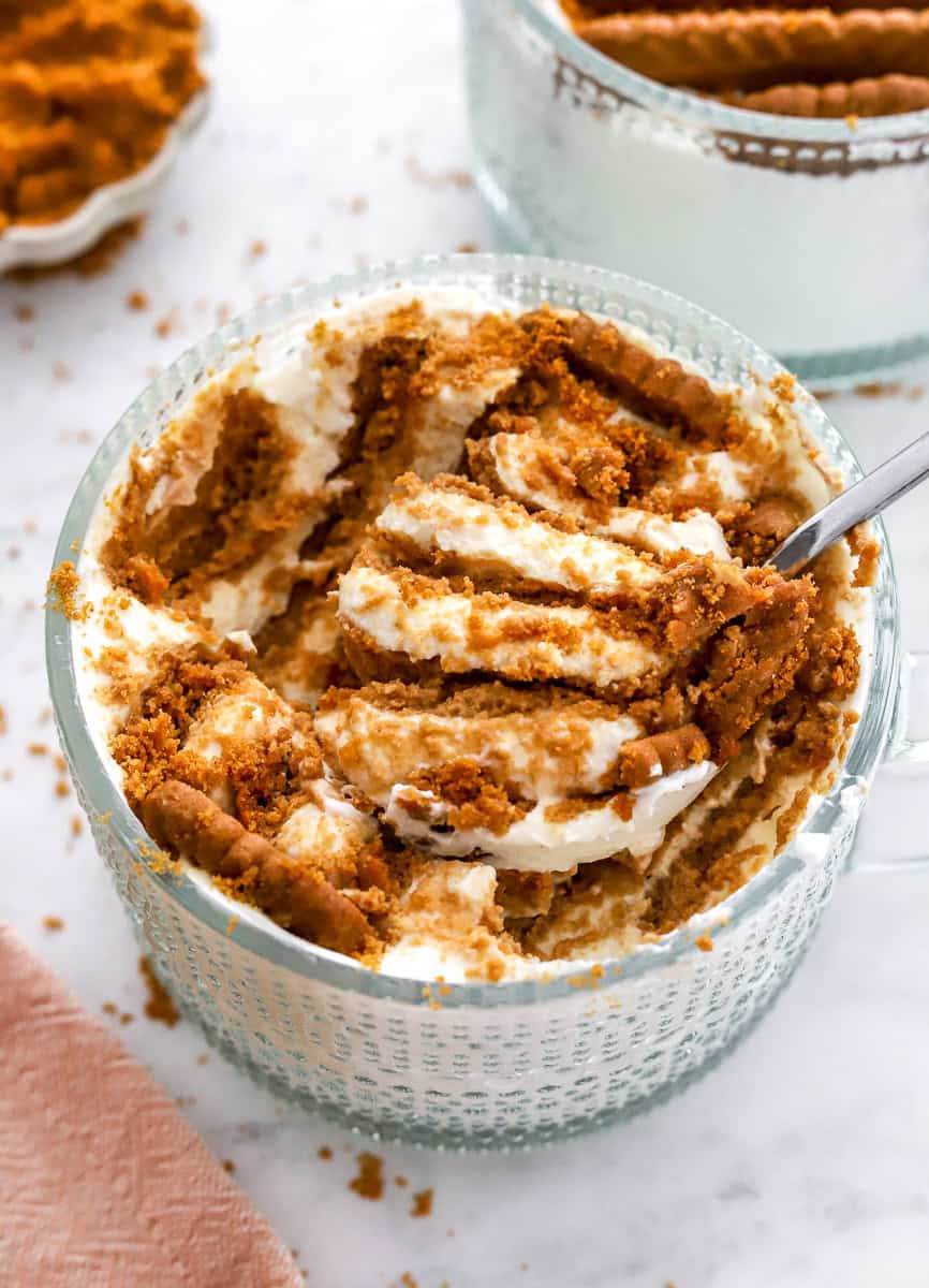 Viral greek yogurt cheesecake in a glass dish with a spoon in the dish with some on it.