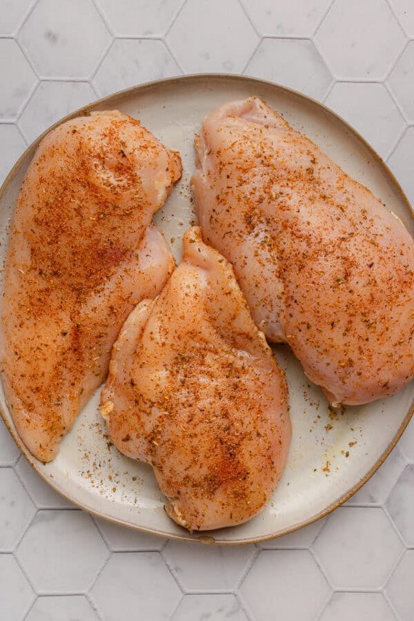 Seasoned chicken breast on a plate.