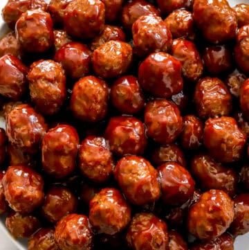 Plate of crockpot bbq meatballs with a pink towel next to the plate.