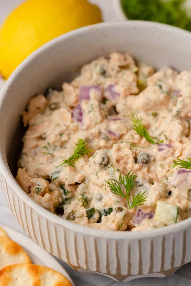 Bowl of creamy dairy free salmon salad topped with dill. 