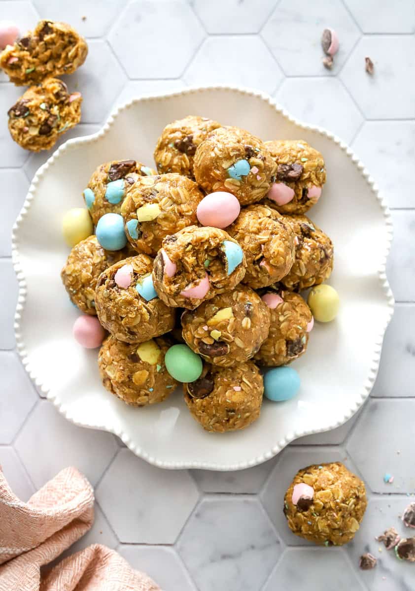 Plate of mini Cadbury egg protein balls on a plate with a pink towel in front of it.