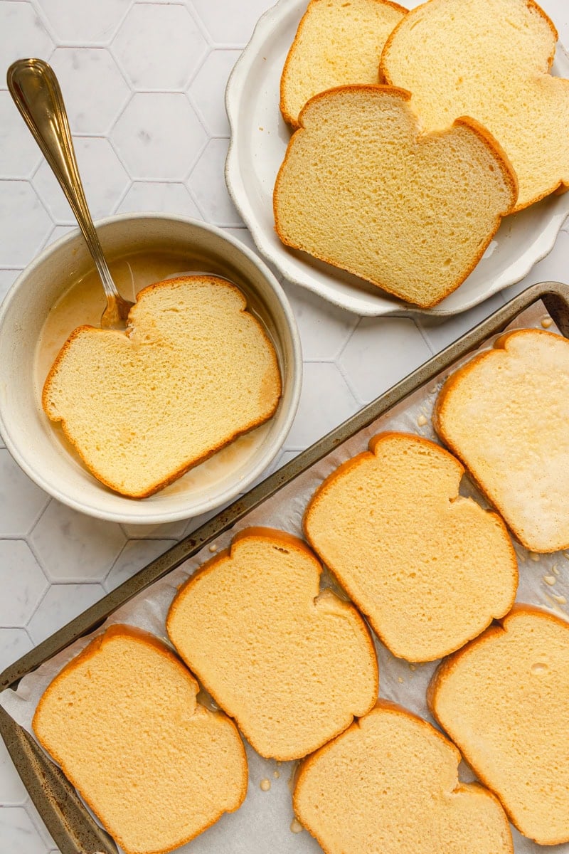 Soaked brioche bread on a baking pan before being cooked. 