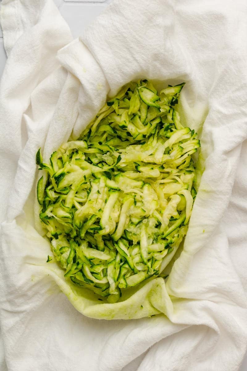 Shredded zucchini in a cloth with the water squeezed out. 
