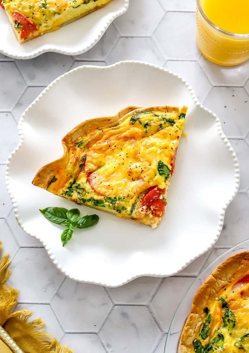 Healthy egg and veggie egg bake with tortilla crust slice on a plate with more behind it.