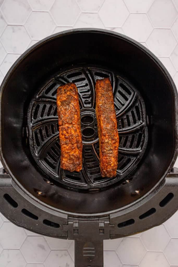 Air fried cajun salmon filets in air fryer basket. 
