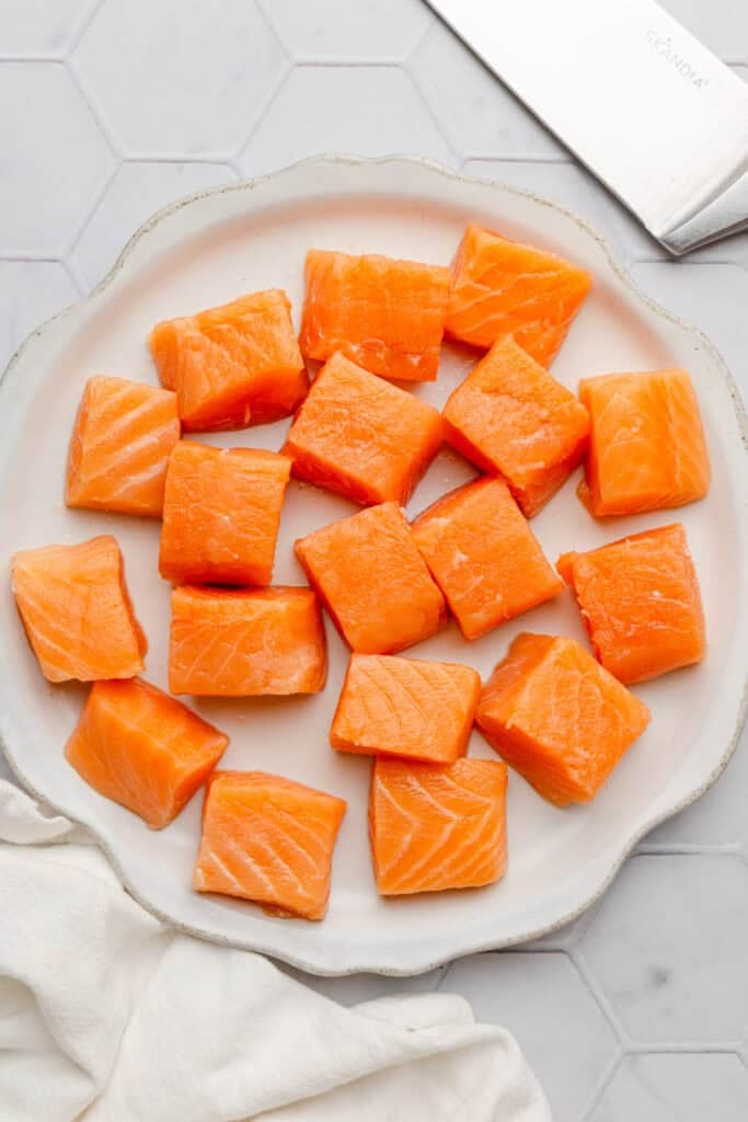 Raw cubed salmon on a plate.