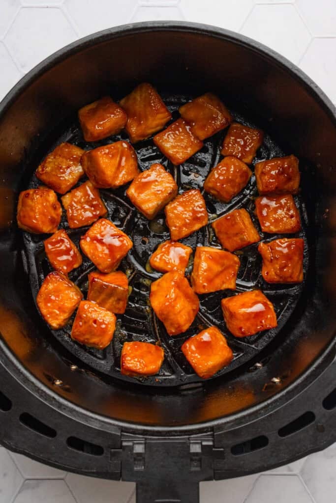 Air fried teriyaki salmon bites in an air fryer basket.