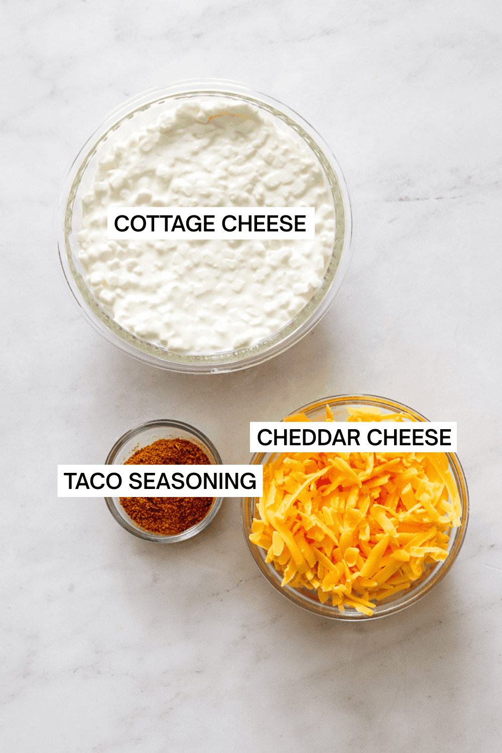 Ingredients for cottage cheese queso dip in bowls with labels over each ingredient.