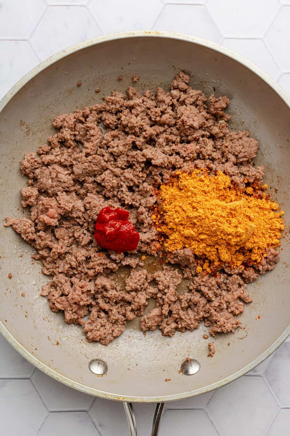 Ground beef, taco seasoning and tomato paste in a skillet.