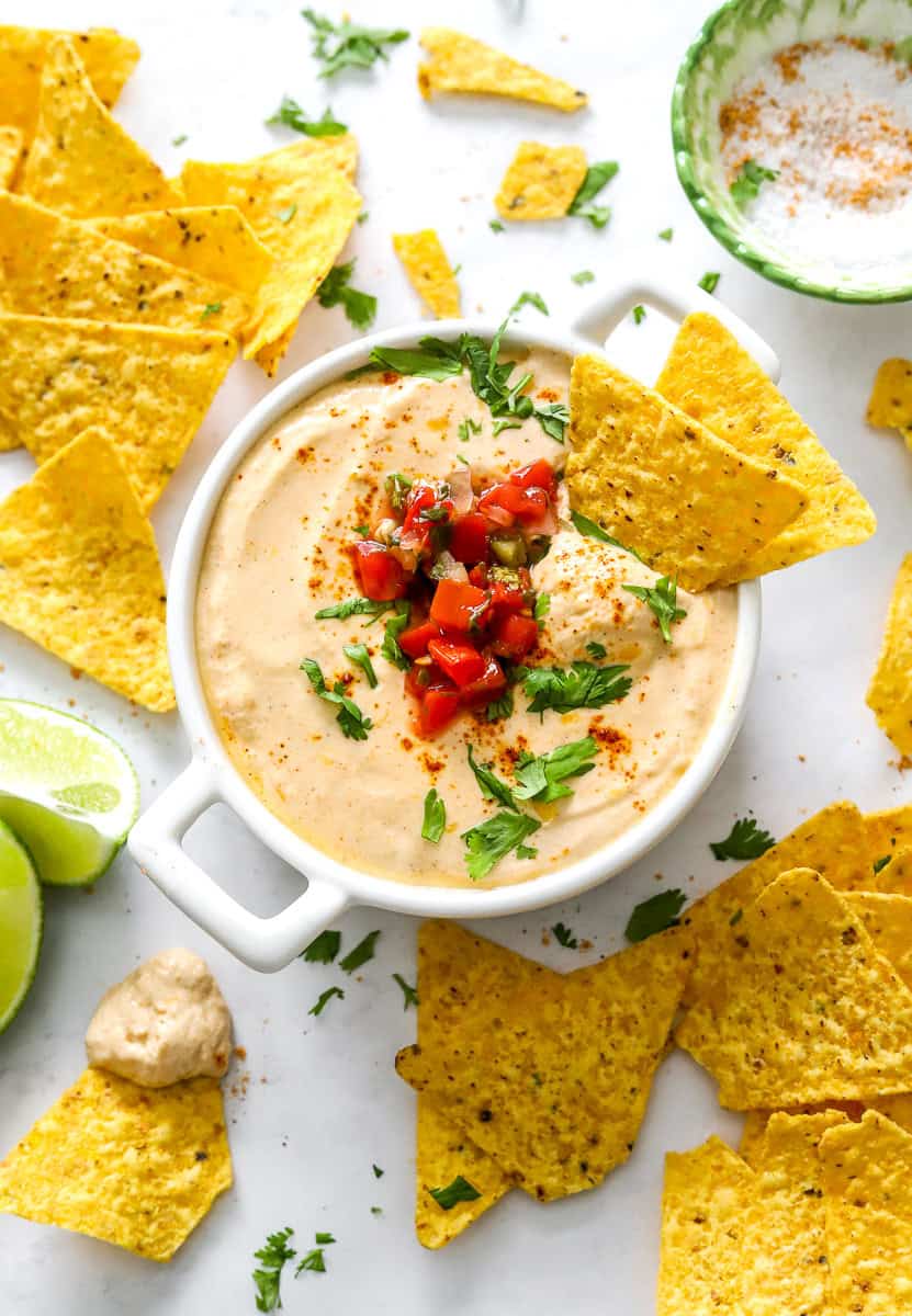 Queso with cottage cheese in a white dish with chips around it.