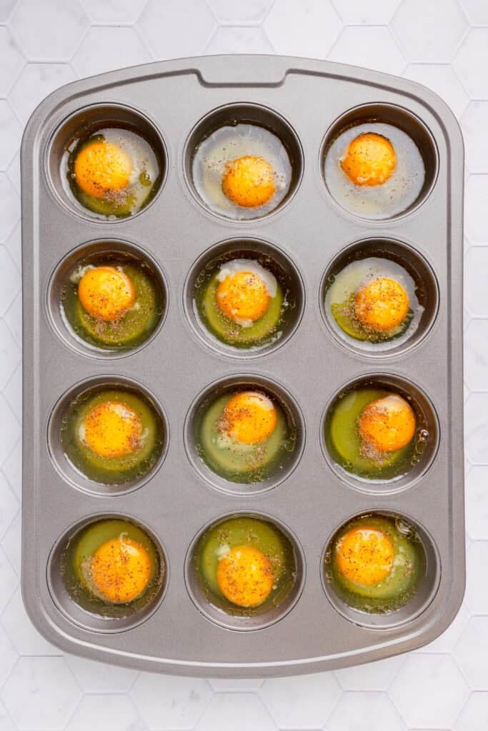 Cracked whole eggs in muffin pan. 