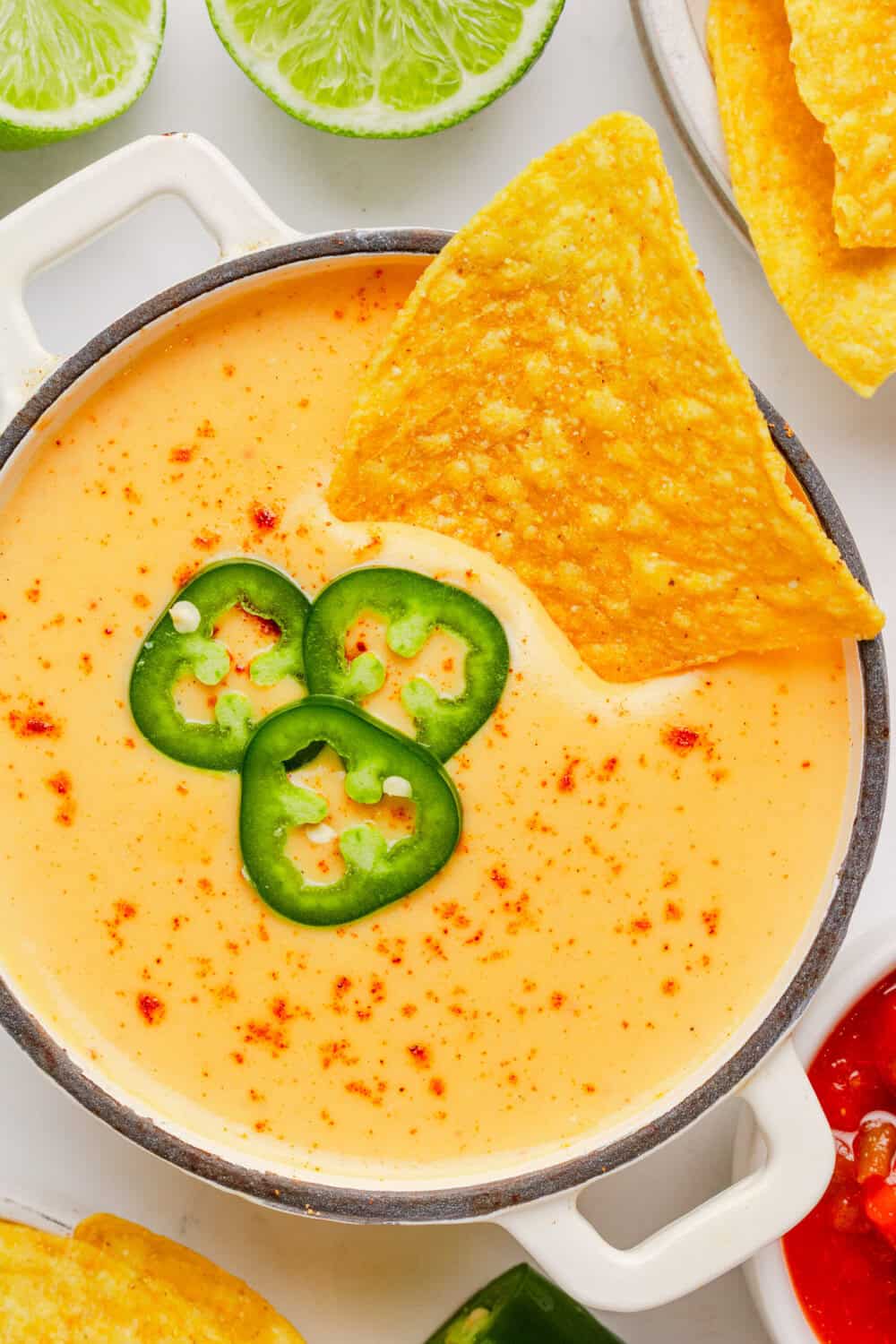 Homemade healthy 3 ingredient queso sauce in a small pot with a tortilla chip in the pot. 