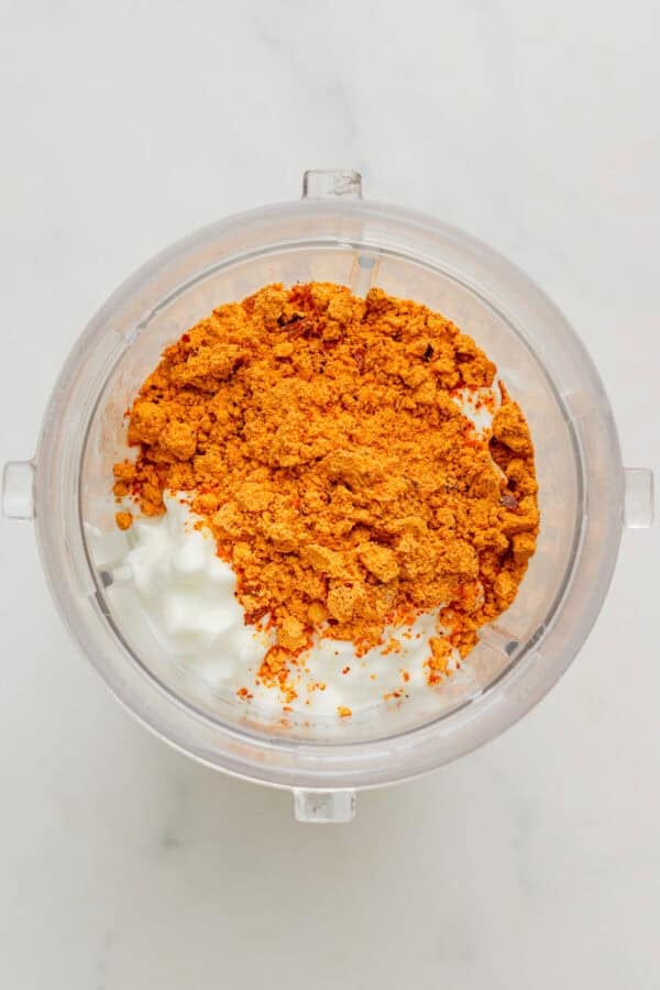 Cottage cheese and taco seasoning in a blender before being blended.