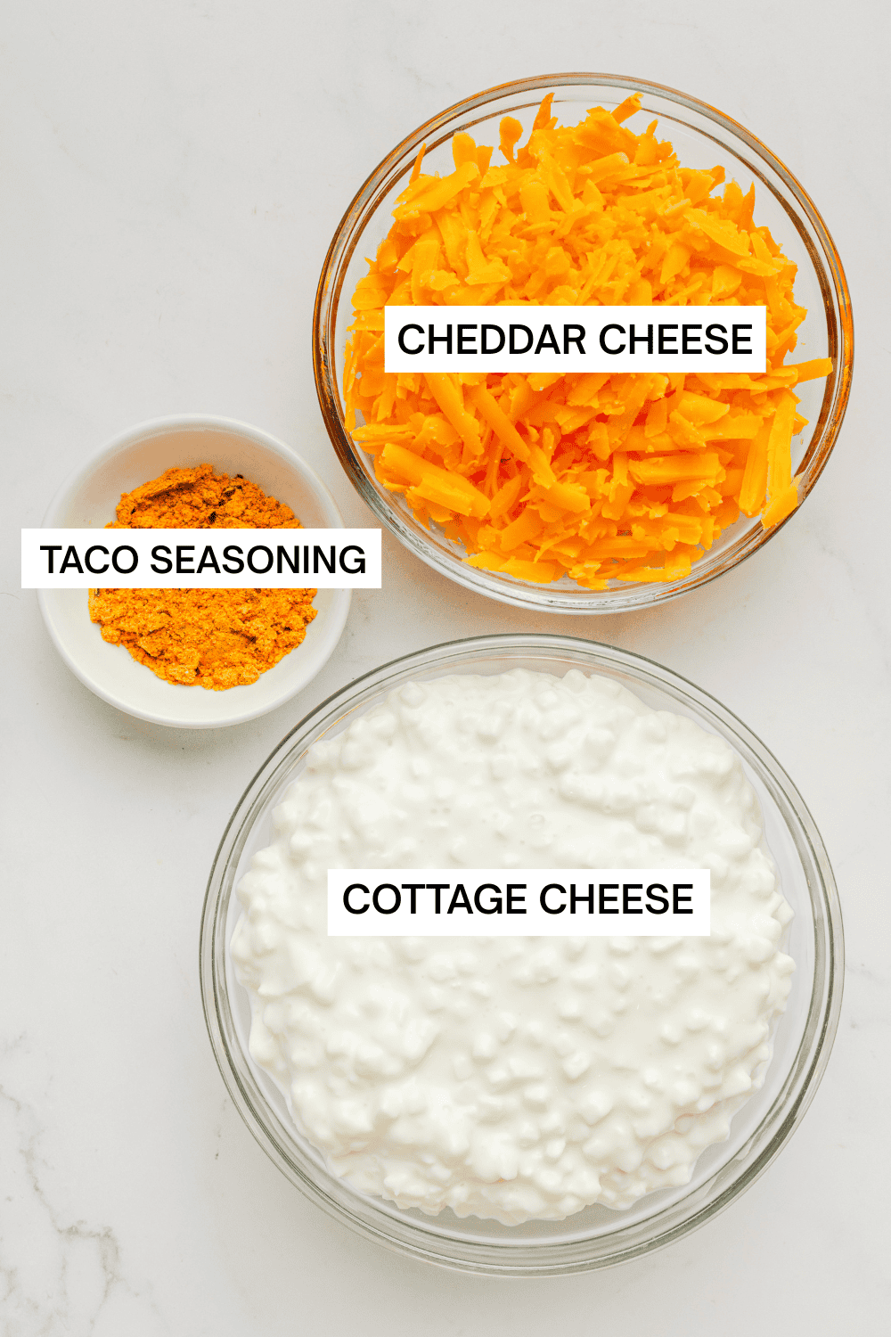 Ingredients for cottage cheese queso dip in bowls with labels over each ingredient.