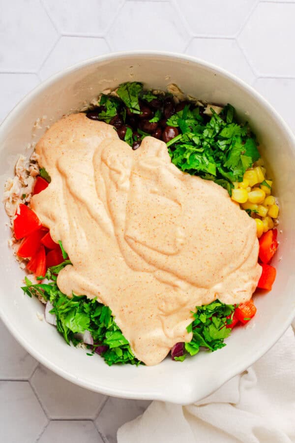 Tuna salad in a bowl with the dressing on top of it.