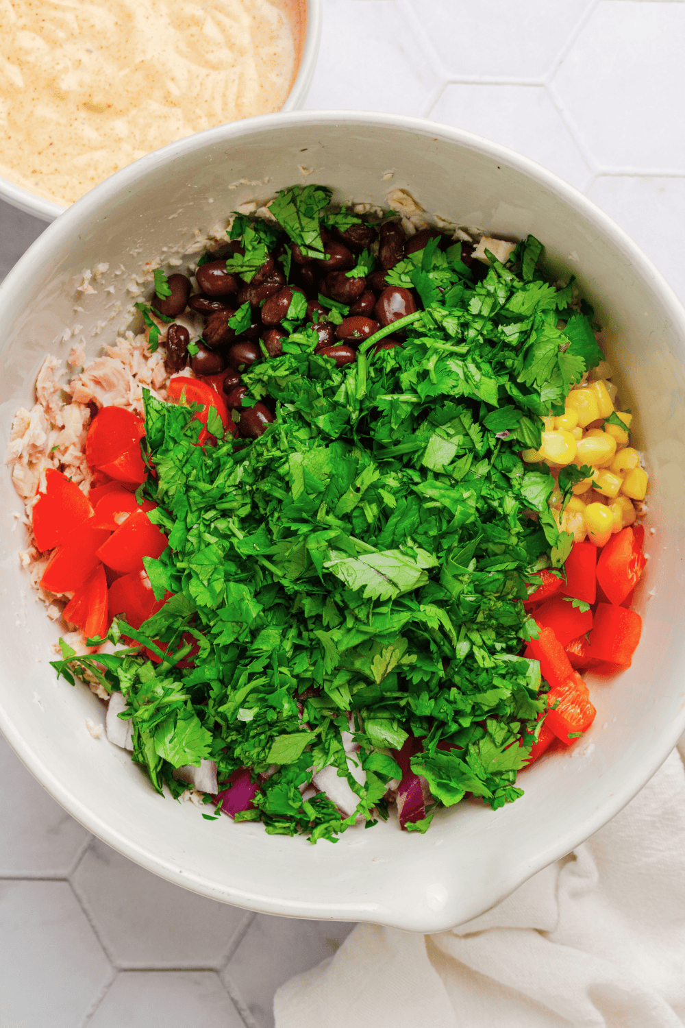 Tuna salad ingredients in a mixing bowl before being mixed up.