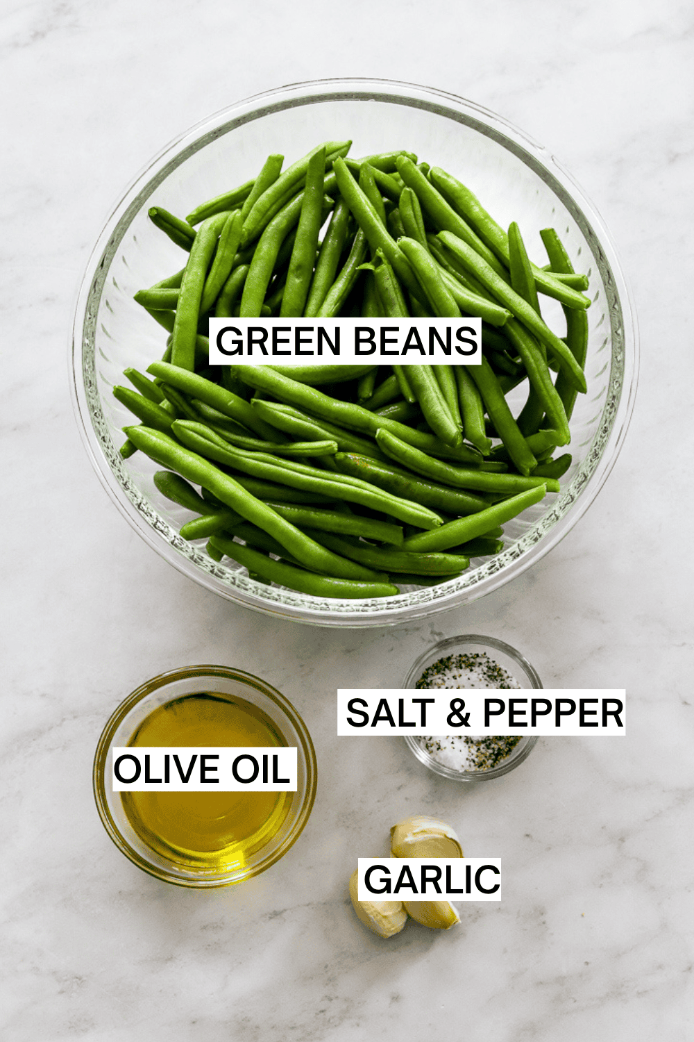 Ingredients for sautéed green beans with garlic in bowls with labels over each ingredient. 