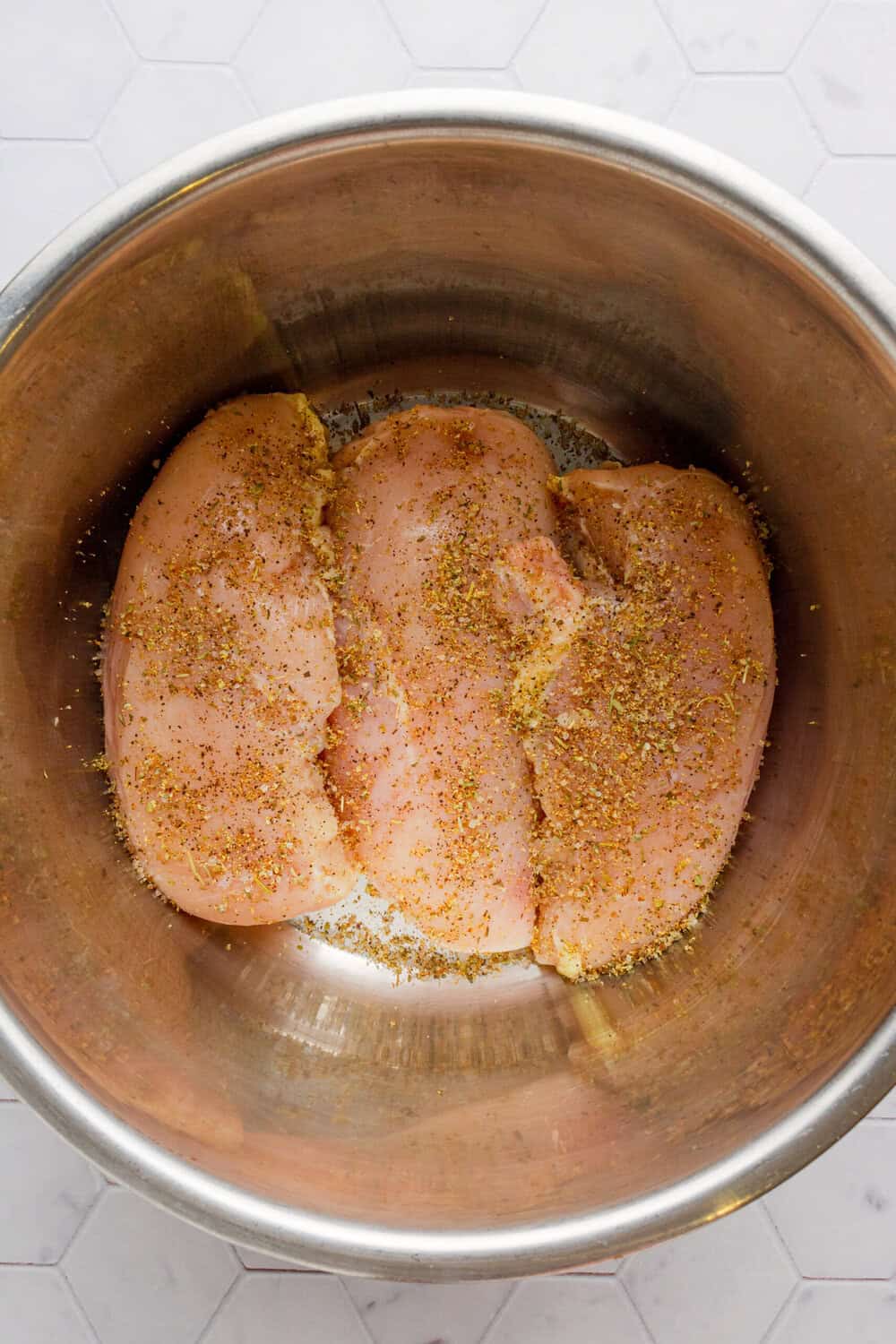 Uncooked, seasoned chicken breast in an Instant pot. 