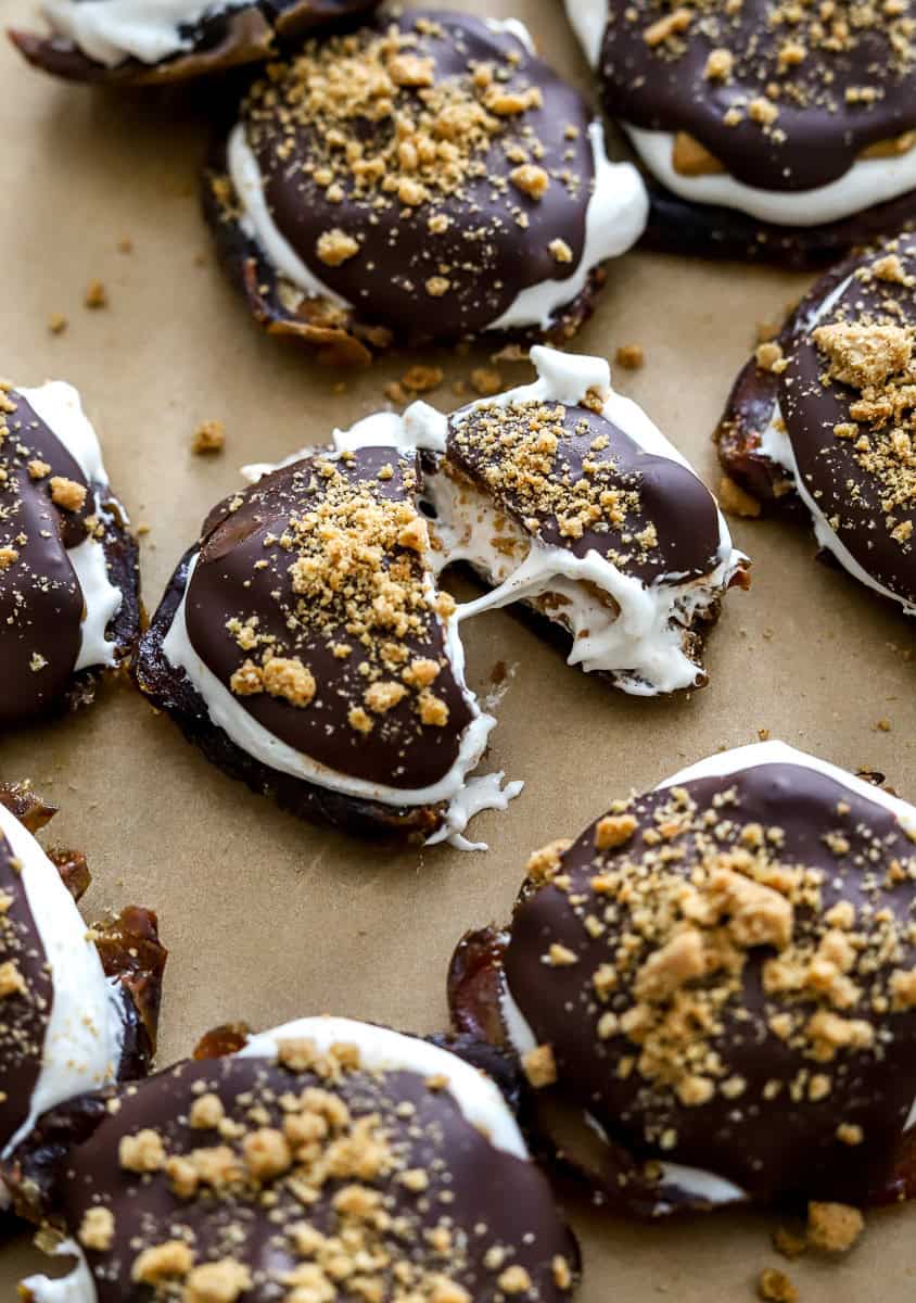 Cut s'mores date covered in a chocolate graham cracker coating with more date s'mores next to it.