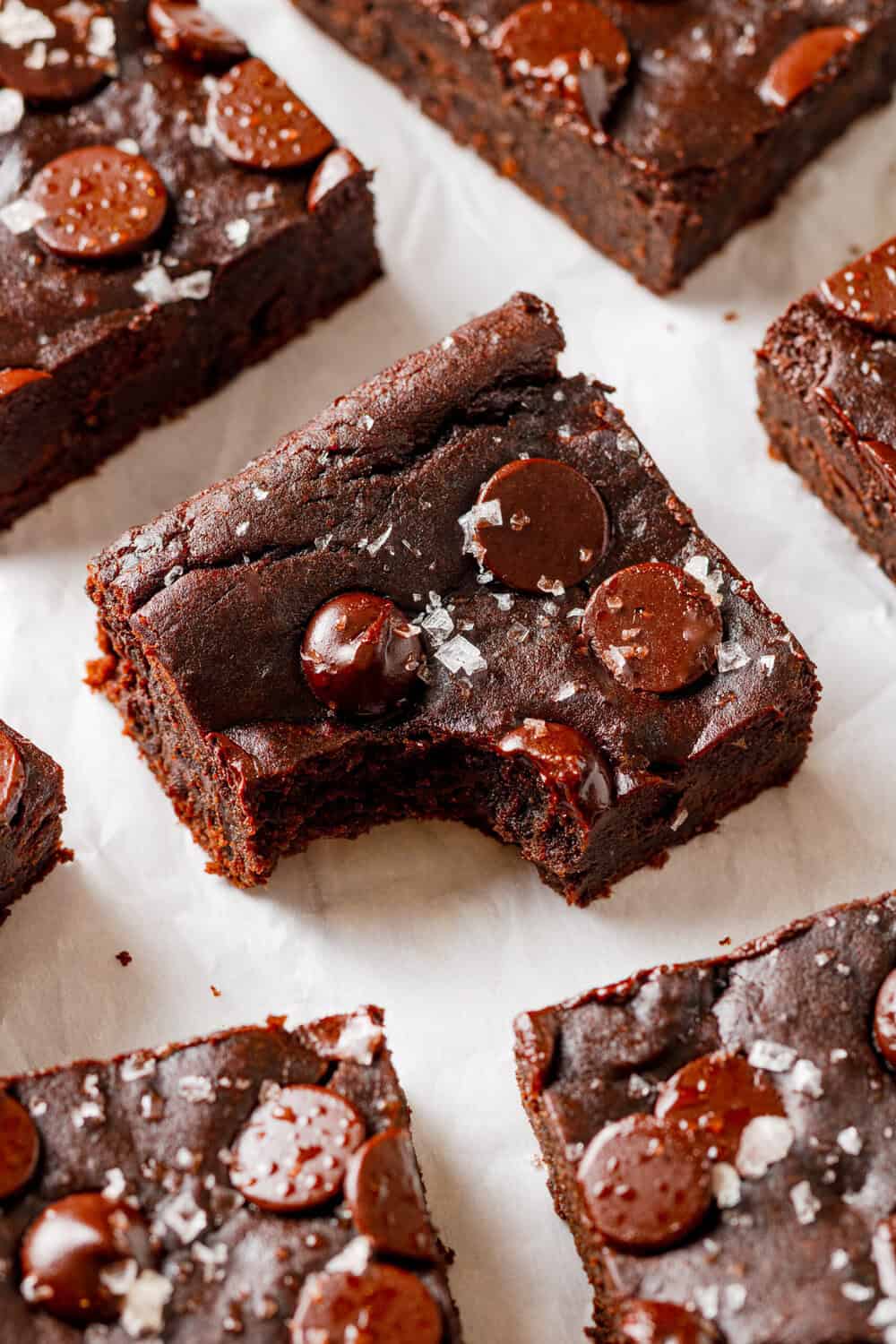 Black bean avocado brownie with a bite taken out of it with more brownies around it.