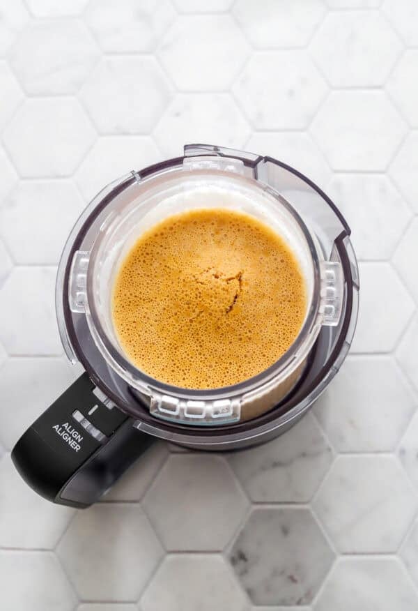 Frozen pumpkin ice cream mixture in Ninja Creami container.