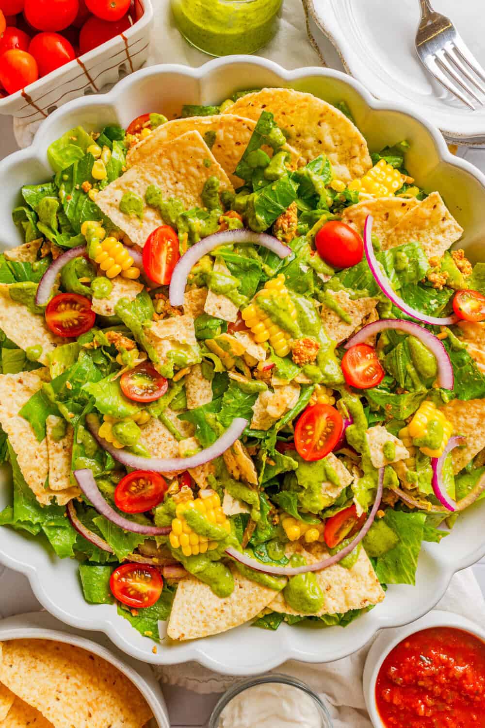 Platter filled with chicken taco salad with cilantro dressing with tortilla chips in the bowl. 