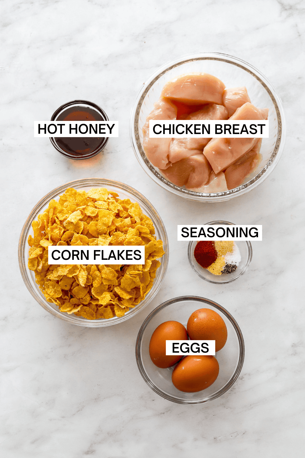 Ingredients for air fried crispy hot honey chicken in bowls with labels over each ingredient. 