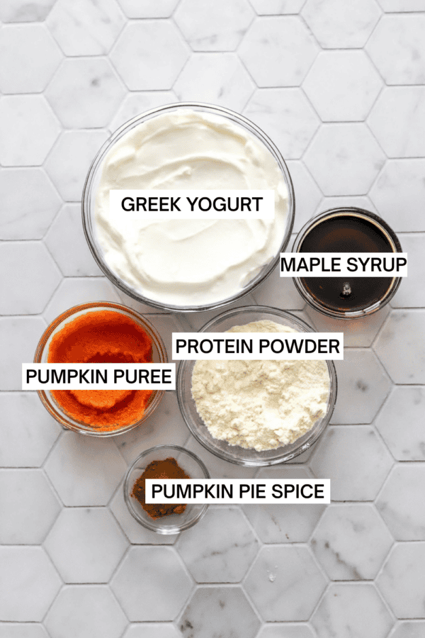 Pumpkin ice cream ingredients in bowls with labels over each ingredient.