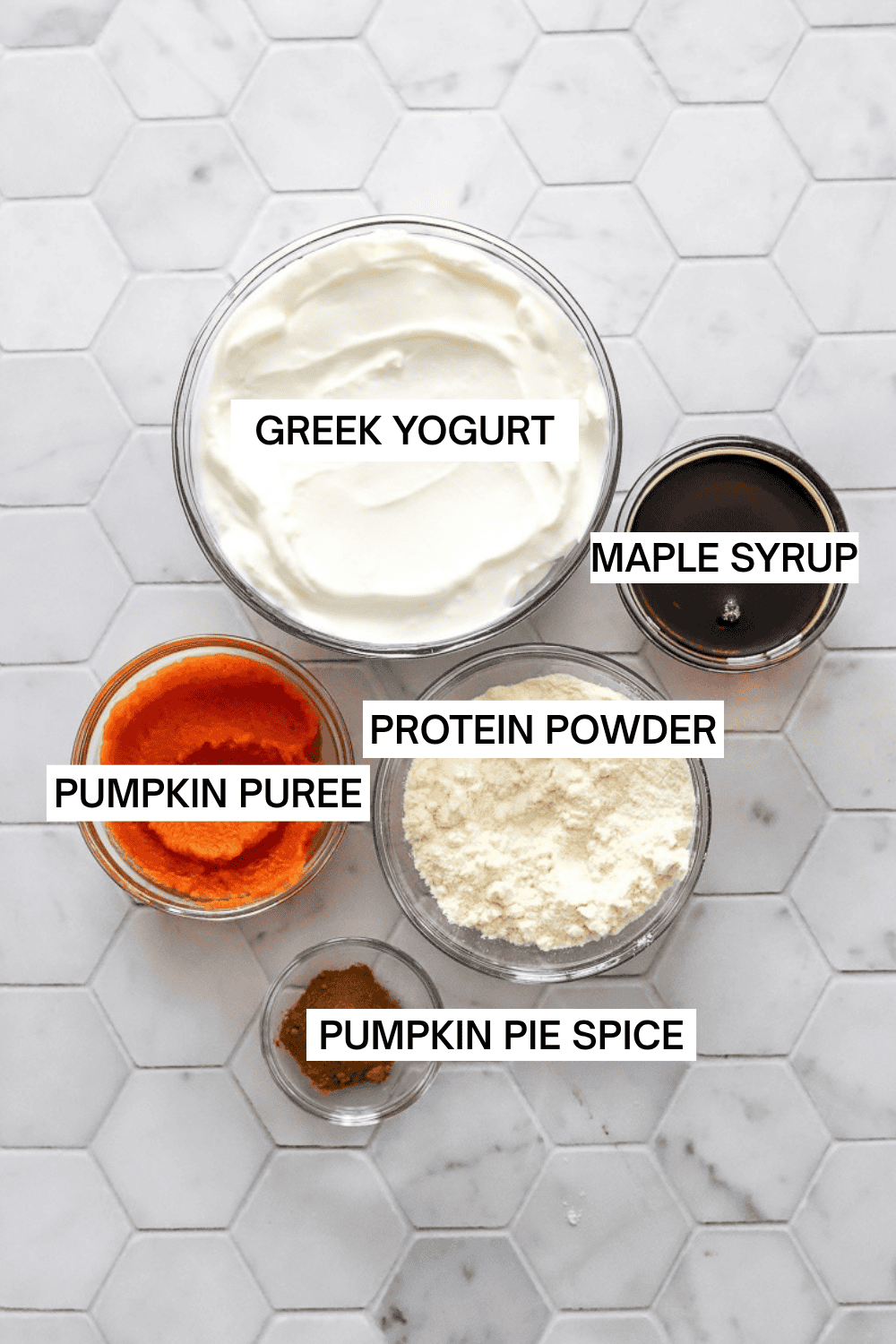 Pumpkin ice cream ingredients in bowls with labels over each ingredient.