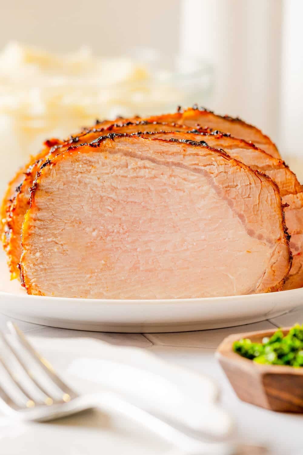 Sliced juicy cooked pieces of air fried pork loin roast on a plate. 