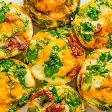 Egg white muffins filled with veggies and cheese on a plate.