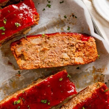 Slices of gluten free meatloaf on a lined pan.