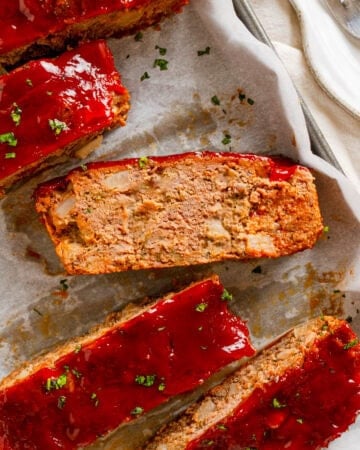 Slices of gluten free meatloaf on a lined pan.