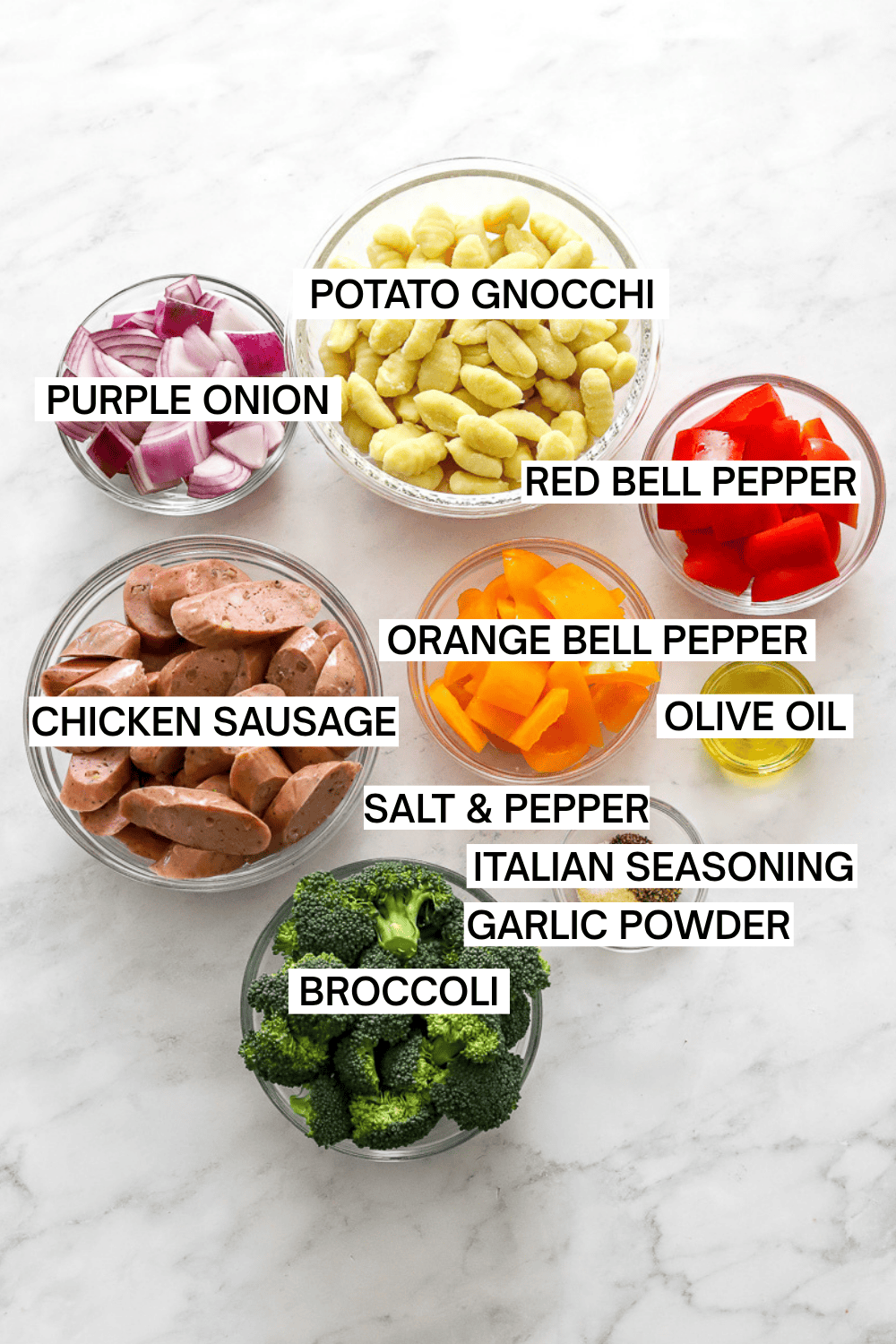 Ingredients for sheet pan gnocchi and sausage in bowls with labels over each ingredient.