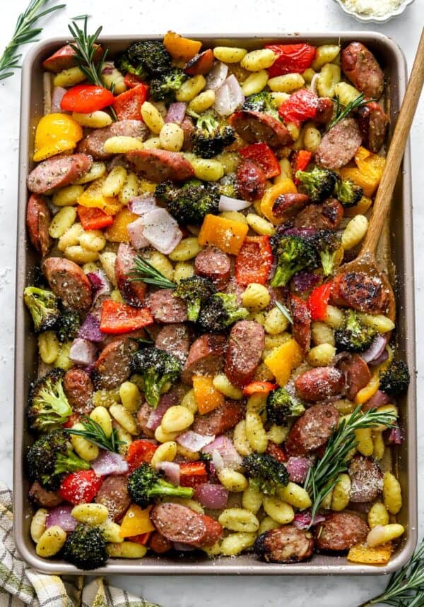 Large sheet pan filled with roasted chicken sausage, potato gnocchi and veggies.