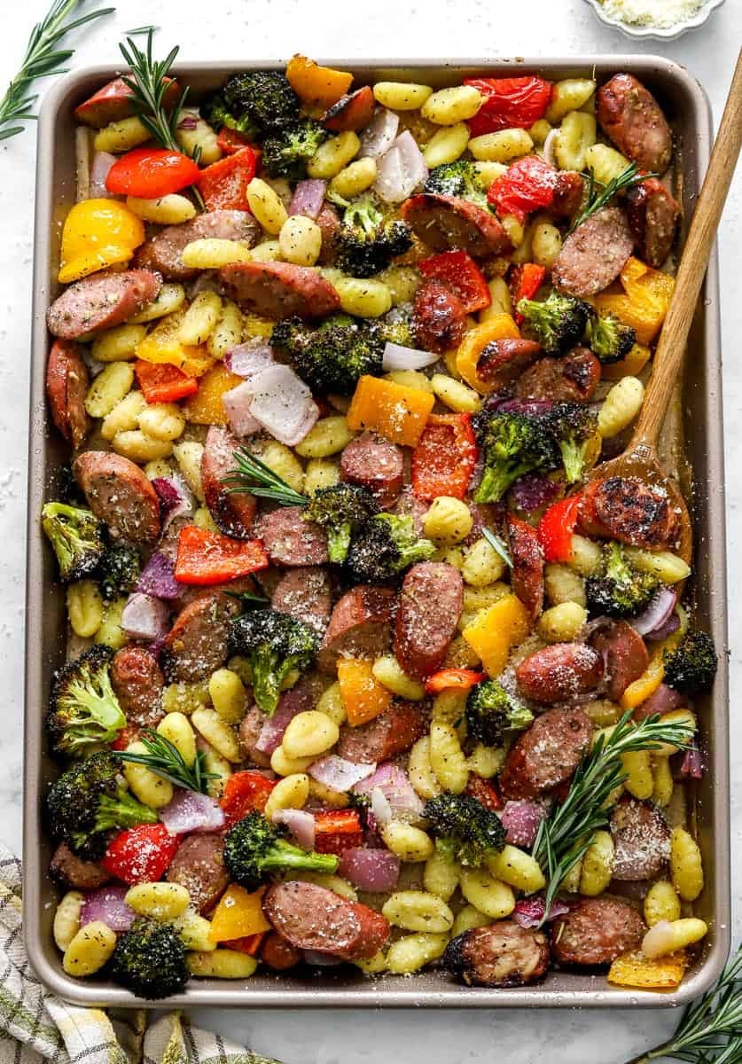 Large sheet pan filled with roasted chicken sausage, potato gnocchi and veggies.